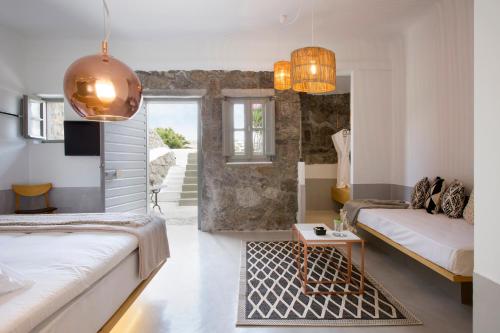 a living room with two beds and a table at The Dimora by Mazera in Ornos
