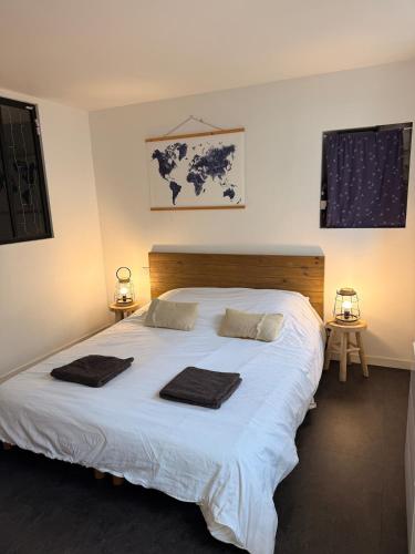 a bedroom with a large white bed with towels on it at Granville appartement in Granville