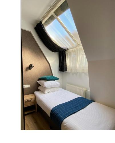 une petite chambre avec un lit et une fenêtre dans l'établissement Hotel Vondel Garden, à Amsterdam