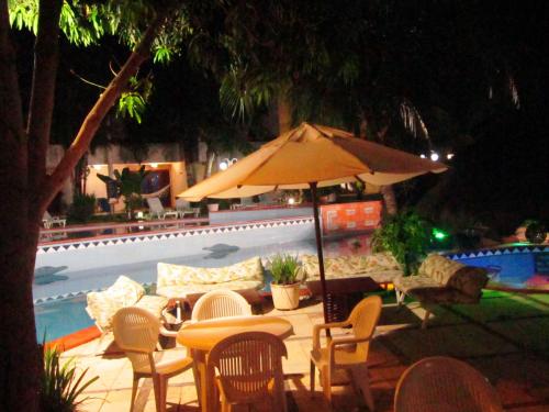 a table and chairs and an umbrella next to a pool at Chalet Solar Pipa in Pipa