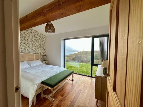 a bedroom with a bed and a large window at Speuran Mora in Teangue