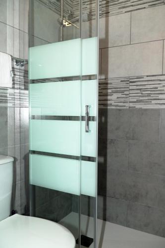 a glass shower door in a bathroom with a toilet at B&B L'Angelica in Piazza Armerina
