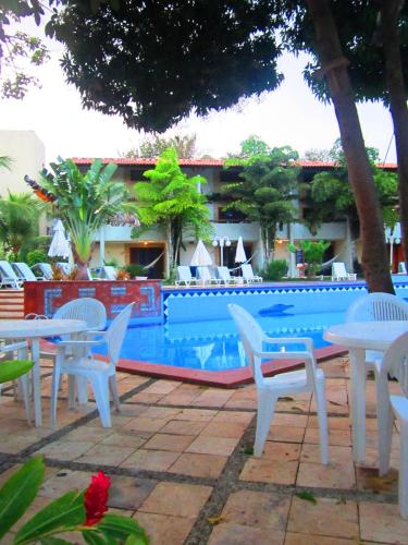 a group of tables and chairs next to a pool at Chalet Solar Pipa in Pipa