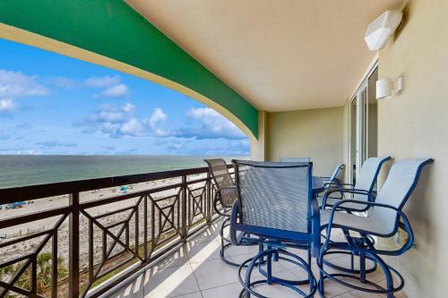 a balcony with chairs and a view of the ocean at Roomy beachfront condo with full kitchen shared pool and beach access in Fort Walton Beach