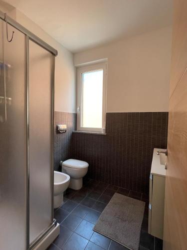 a bathroom with a toilet and a sink and a window at Relax Ligure in Boissano