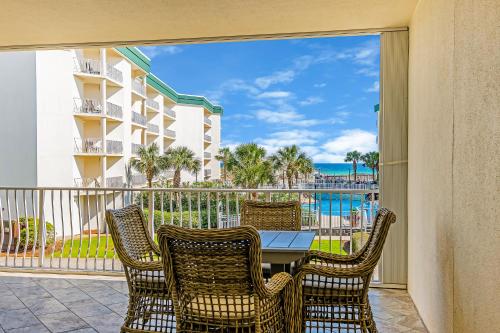 a balcony with a table and chairs and a view of the ocean at Chic first-floor condo with Gulf & pool view & pickleball - steps to beach in Santa Rosa Beach