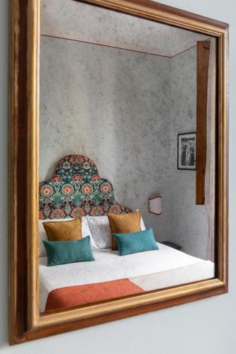 a mirror reflecting a bed in a bedroom at Hotel Galileo in Florence