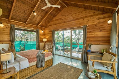 a bedroom with a bed and a balcony at SaffronStays Anjee's Chalet in Dhamni