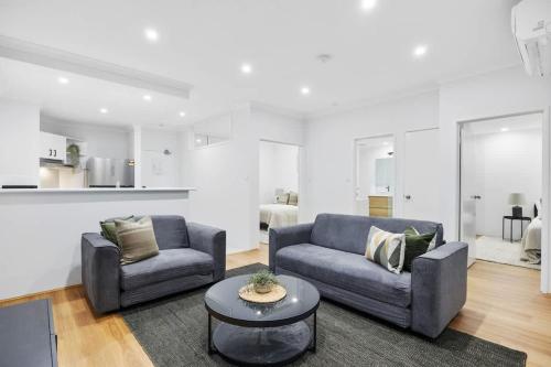a living room with two couches and a table at River Fringe Urban Retreat in Perth