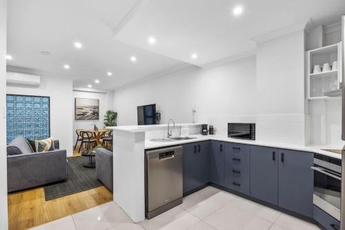 a kitchen with a sink and a living room at River Fringe Urban Retreat in Perth