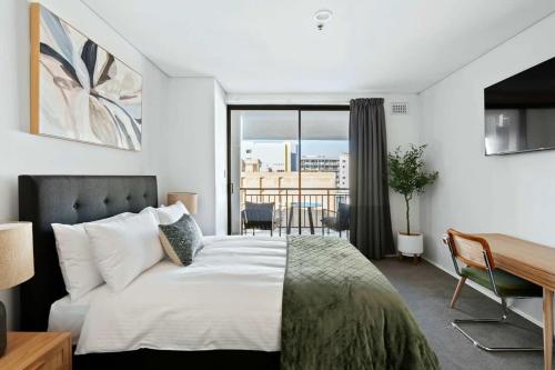 a bedroom with a bed and a desk and a window at Walk Everywhere - Large Apartment & Sofa Bed in Perth