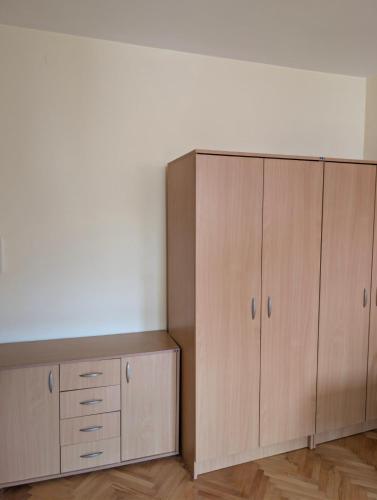 a large wooden cabinet in a room with wooden floors at KRAGUJ apartments 1 in Kragujevac