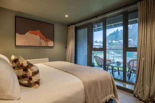 a bedroom with a bed and a large window at 34 Ironworks in Backbarrow