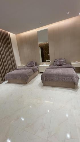 two beds in a large bedroom with marble floors at ستارز هاوس in Najran