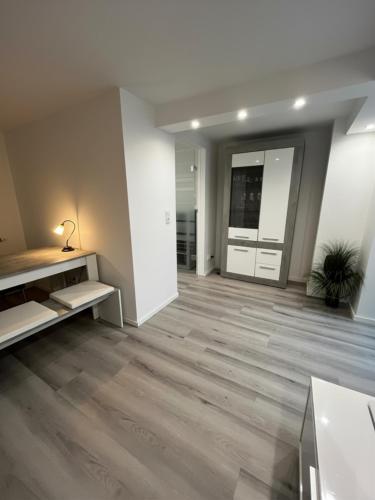 an empty living room with wood floors and a hallway at Modernes Apartment nahe Frankfurt, Rodenbach & Hanau in Rodenbach