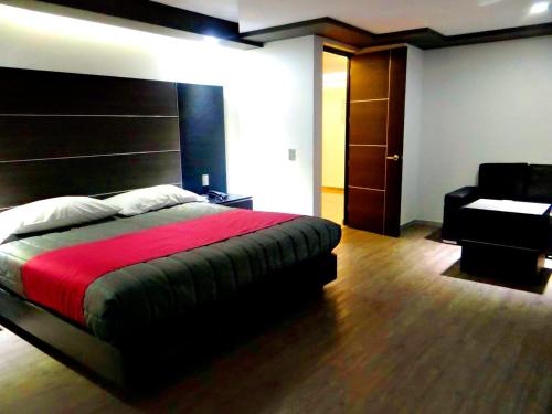 a bedroom with a large bed and a chair at H Boutique Touca in Toluca
