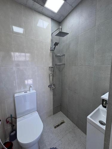 a bathroom with a white toilet and a shower at Luxury A-Frame Forest Chalet in Gabala