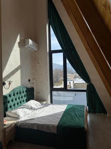 a bedroom with a bed and a large window at Luxury A-Frame Forest Chalet in Gabala
