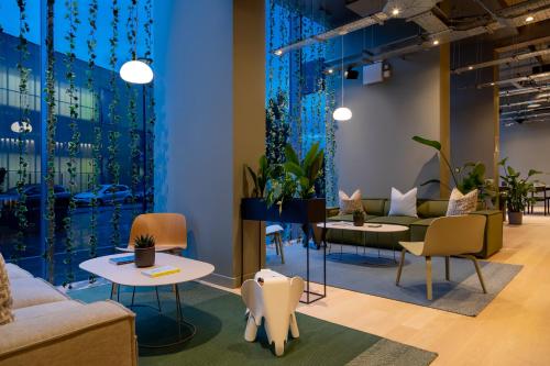 a waiting room with couches and tables and plants at Zedwell Hotel Greenwich in London