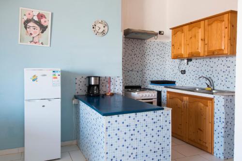 a kitchen with a white refrigerator and a sink at aparthotelboavista-net in Sal Rei