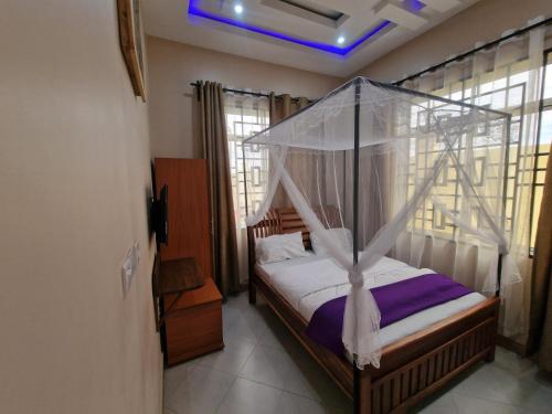 a bedroom with a bed with a canopy at Mamucha Grand Lodge in Arusha
