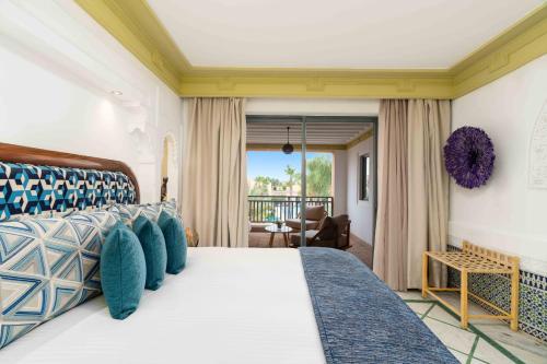 a bedroom with a large bed with blue pillows at Jaal Riad Resort Adults Only in Marrakesh