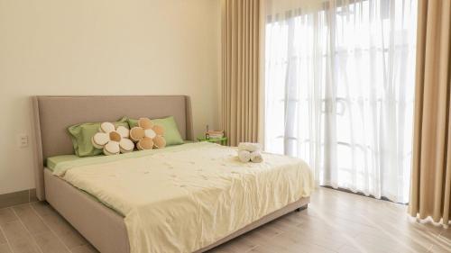 a bedroom with a bed with a teddy bear on it at Bơ Home Novaworld in Phan Thiet