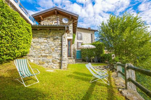 two chairs sitting in the yard of a stone house at Casa La Terrazza Uno C in Cannobio