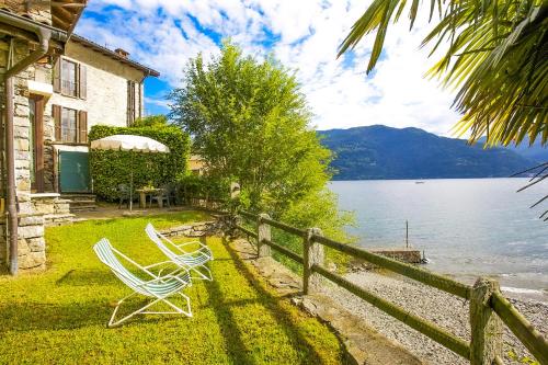 two chairs sitting on the grass next to a house at Casa La Terrazza Uno C in Cannobio