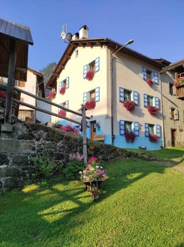 a white house with flowers in a yard at Ciesa del Selmo Faure in Sottoguda
