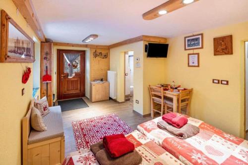 a room with two beds and a table and a kitchen at Ciesa del Selmo Faure in Sottoguda