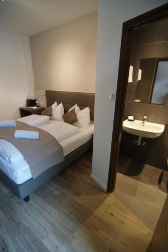 a hotel room with a bed and a sink at Hotel Raffl in Bolzano