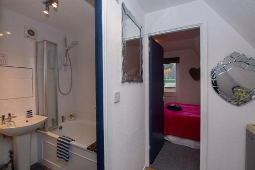 a bathroom with a shower and a sink and a tub at Chalet Three in Deal