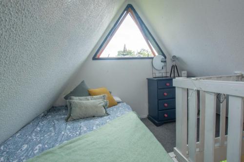 a small bedroom with a bed and a window at Chalet Three in Deal