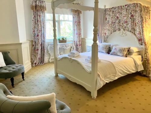 a bedroom with a canopy bed and a chair at Storrs Gate House B & B No pets Allowed in Bowness-on-Windermere