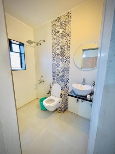 a bathroom with a toilet and a sink at ll MOCKTAIL VILLA ll 3BHK ll AC ll PRIVATE POOL ll MALAVALI ll in Lonavala