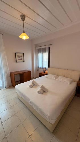 a bedroom with a white bed with two towels on it at Kỳma - Stone Luxury Villa in Órmos Koumaíïkon