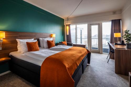 a hotel room with a large bed with a green wall at Hotel Atlantic in Aarhus