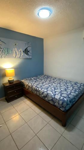 a bedroom with a bed and a lamp on a table at Casa pequeña in Acapulco