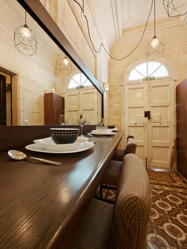 a dining room with a long wooden table and chairs at Casa Maltija in Sliema