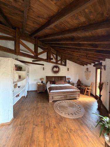 a large bedroom with a bed and wooden ceilings at Antu Wellness cabaña de lujo en paine in Maipo