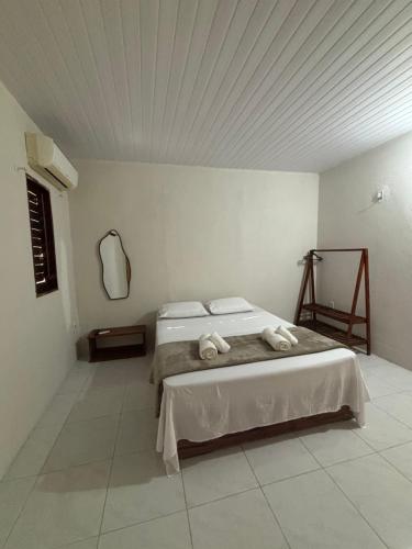 a bedroom with a bed with two towels on it at Pousada Casa Marelle in Paracuru