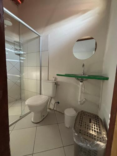 a bathroom with a toilet and a glass shower at Pousada Casa Marelle in Paracuru