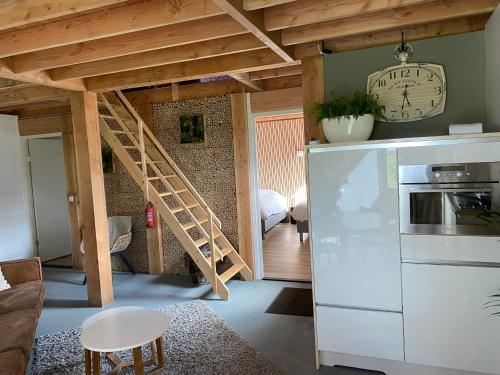 a kitchen with a staircase in a room with a refrigerator at B&B Logeren bij van Heeren in Made