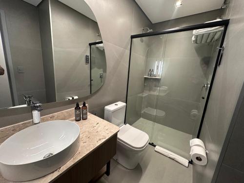 a bathroom with a toilet and a sink and a shower at Slaviero Prime Campo Grande in Campo Grande