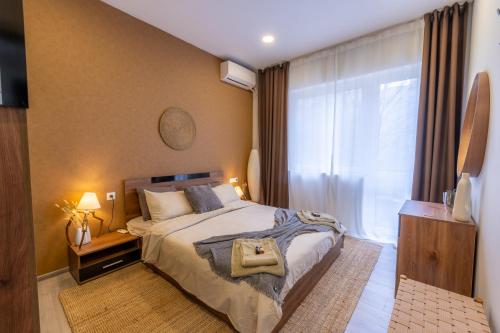 a bedroom with a bed and a large window at NDK - UrbanLux Medius 2BDR FREE Parking in Sofia