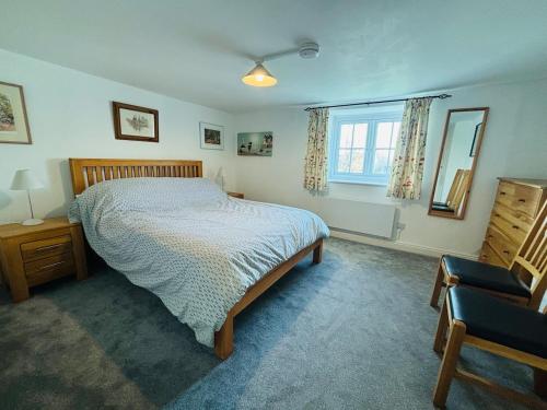 a bedroom with a bed and a chair and a window at Kivel Cottage in Portland