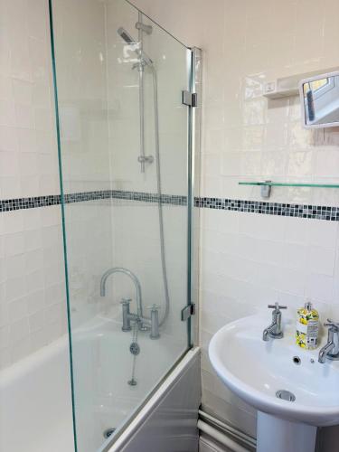 a bathroom with a shower and a sink at Kivel Cottage in Portland