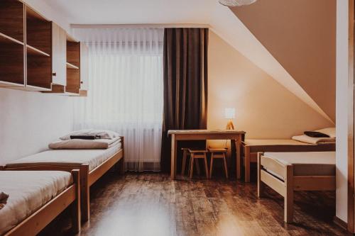 a hotel room with two beds and a desk at Dom Wypoczynkowy U STASKA in Ochotnica Dolna