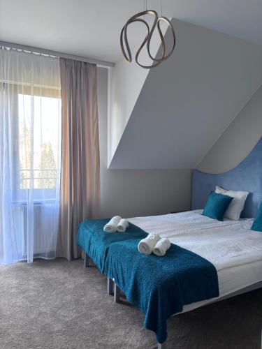 a bedroom with two beds with towels on them at Villa Morska Perła in Rewal